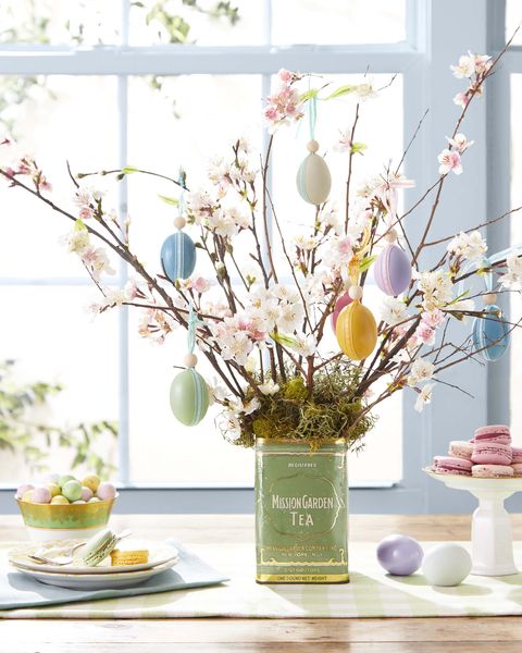 easter egg tree displayed in a vintage tea tin decorated with painted eggs hung with ribbon