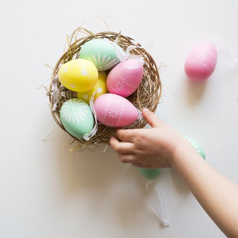 Easter Facts Hand Reaching for Colorful Eggs in Basket