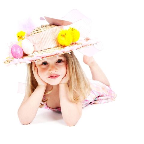 girl in hat decorated for easter with eggs and chicks