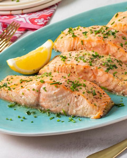 baked salmon with herbs on blue plate lemon