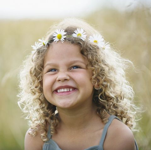 young girl laughing with daisies in hair