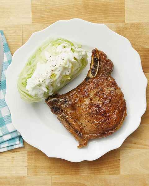 pan fried pork chops on white plate with wedge of lettuce
