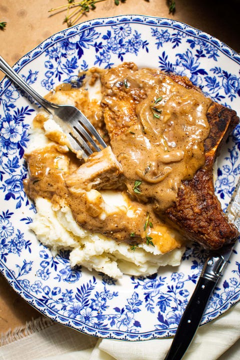 southern smothered pork chops with mashed potatoes on blue plate