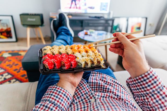 eating sushi delivery at home while laying on the couch, personal perspective view