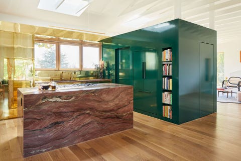 green lacquered cube hold appliances next to an island in pink marble