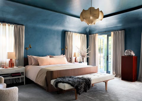 bedroom with blue walls and tall draped windows