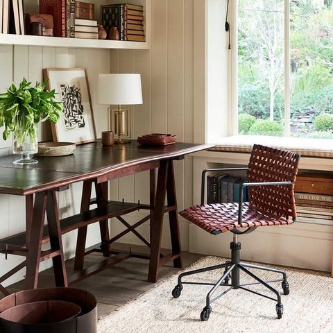 office with wooden desk with a frame legs and a woven leather rolly chair