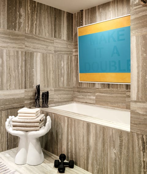 bathroom with marble tub and cupped hand stool holding towels