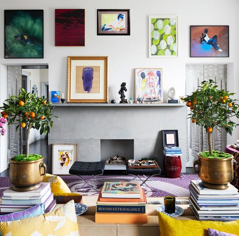 living room with small potted orange plants and fireplace with art
