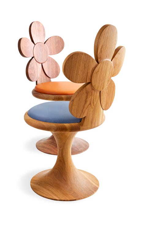 two wooden pedestal chairs with backs in the shape of a daisy and one seat is blue and one is a salmon color