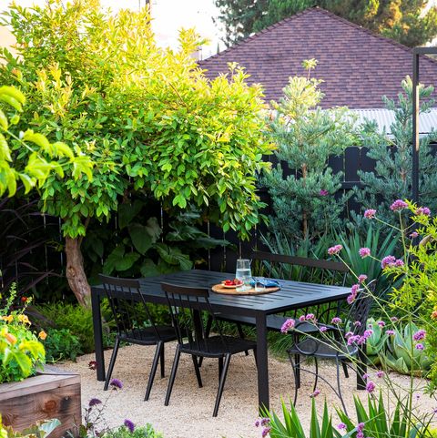 outdoor garden area with black iron table at center