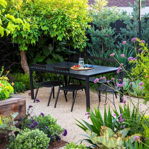 outdoor garden area with black iron table at center