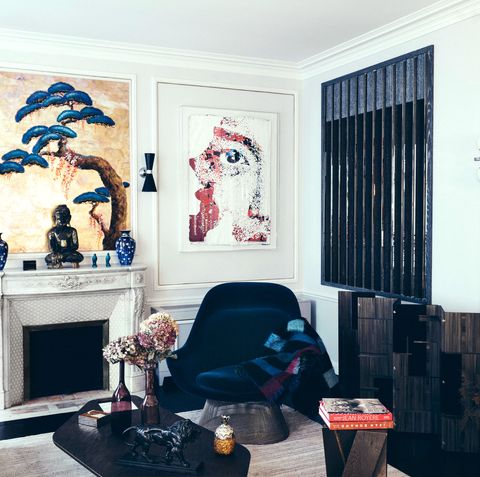 living room corner with a white fireplace dark blue chairs and a painting on the back