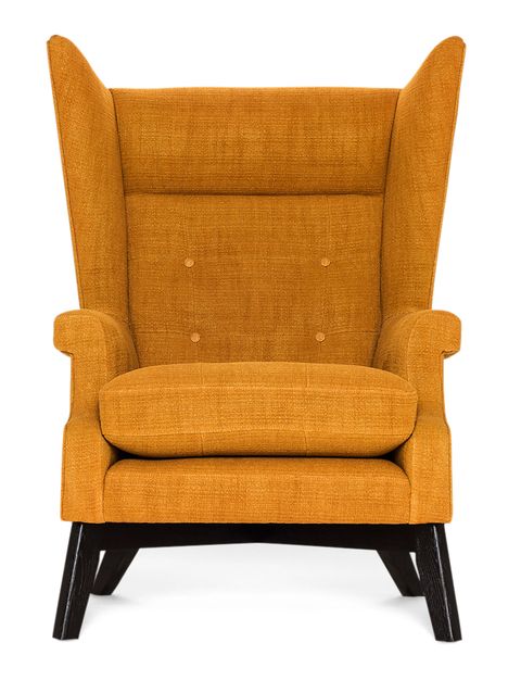 a wingback chair with orangish upholstery plump seat cushion and black legs