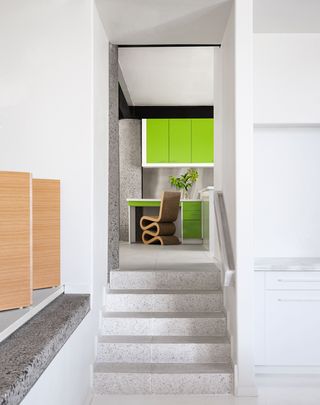 stairway with view of kitchen with acid green cabinetry