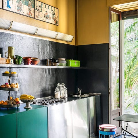 A List 2022 - ELLE DECOR sleek kitchen with some stainless cabinetry and some teal green and open shelving above