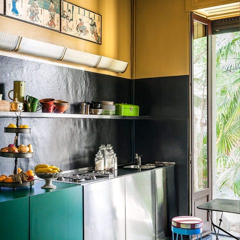 sleek kitchen with some stainless cabinetry and some teal green and open shelving above