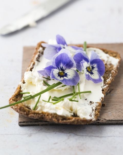 slice of wholemeal bread with cream cheese, chives and edible horned violets