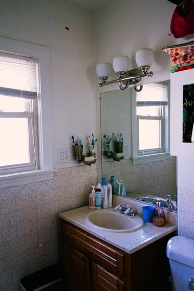 before bathroom with medium wood cabinets and a plain color tile and counter after bathroom with teal tile and some pattern