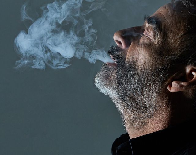 primer plano del actor eduard fernández echando humo de un cigarro por la boca