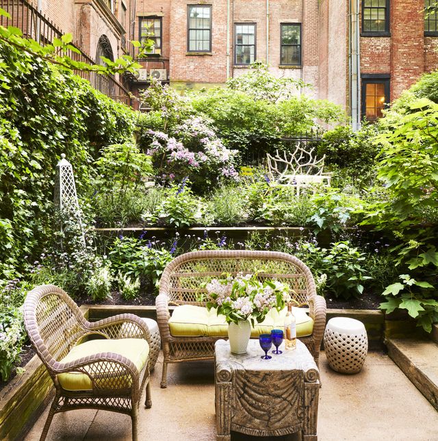 off the eerdmans ground floor bedroom is a private garden ensconced in oak leaf hydrangea, salvia, and lollipop verbena surrounding two wicker love seats and a table