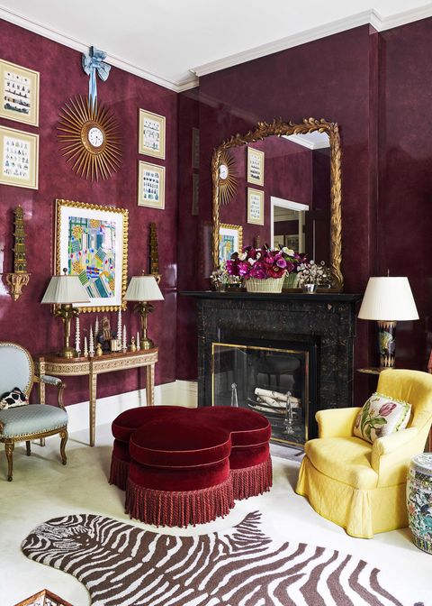 a 19th century french sunburst clock is suspended by a shantung silk bow from mario buattas living room and a velvet ottoman is on the floor in the aubergine walled room