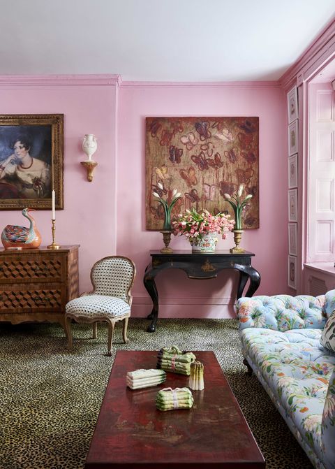 pink walls and leopard print carpet in a room with a floral tufted sofa