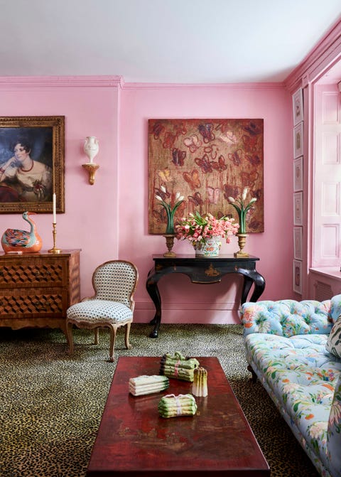 pink walls and leopard print carpet in a room with a floral tufted sofa