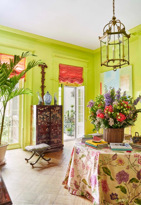 the upper salon is lime green with an octagonal table in the middle skirted in a floral tablecloth