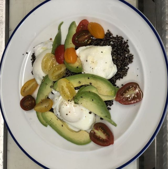 poached eggs, quinoa, tomatoes, and avocado on plate