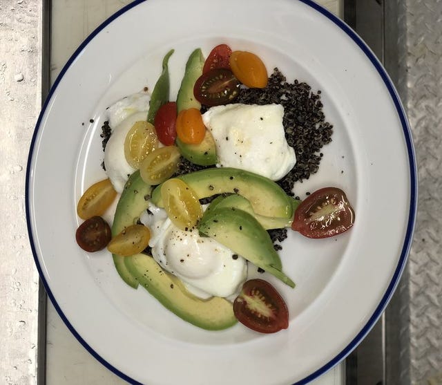 poached eggs, quinoa, tomatoes, and avocado on plate