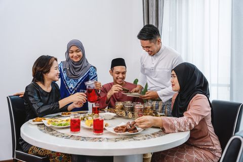 Keluarga dan teman-teman menikmati makanan selama perayaan Idul Fitri Hari Raya