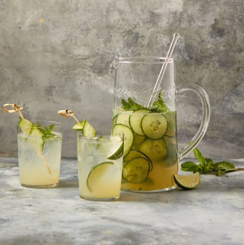 a pitcher and cocktails glasses of elderflower gin cocktail with lime and cucumber