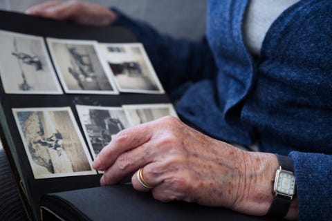 elderly woman looking at old fashioned photograph album