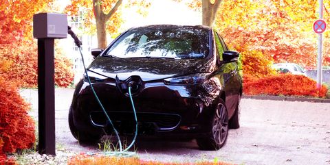 electric car charging on road against autumn trees