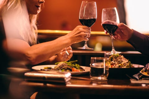 Elegant mature couple dining and toasting with wine at restaurant