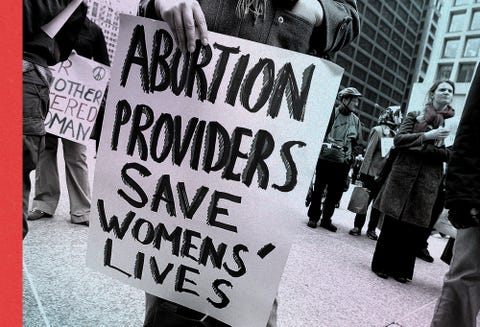 a rally participant holds a sign that reads "abortion providers save womens' lives" during an international women's day march in chicago