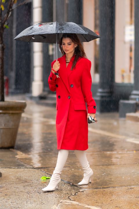 Emily Ratajkowski con abrigo largo rojo y botas altas blancas