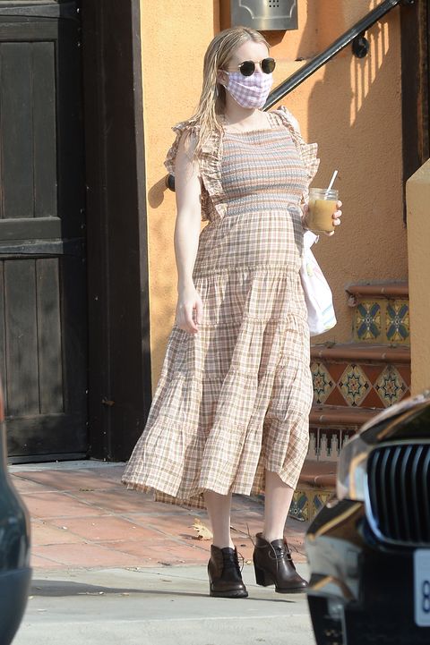 Emma Roberts con vestido largo de cuadros y botines de tacón bajo