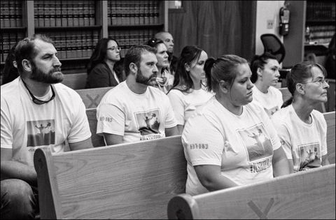 protestors sitting in a courtroom wearing matching tshirts