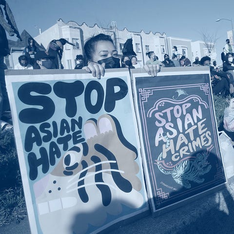Chinatown Anti-Asian Hate Vigil woman holds signs during an anti asian hate vigil the signs read stop asian hate and stop asian hate crimes