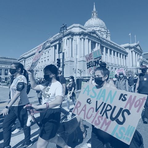 demonstrators hold up signs as they take part in an anti asian american hate march and rally the sign reads asian is not a virus racism is