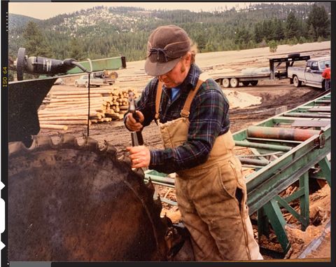 man in flannel shirt working on sawmill