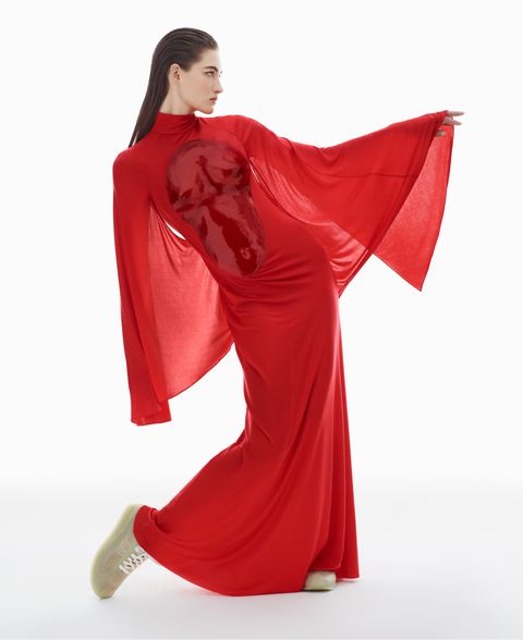 model grace elizabeth wears a red cape dress and sneakers
