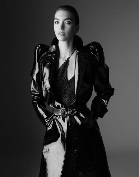 arizona muse wears a shiny black trench coat