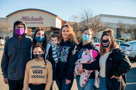 family standing in a michaels parking lot