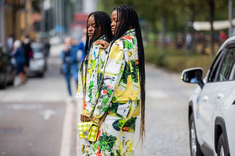 two african american women in matching white, yellow, and green ensembles