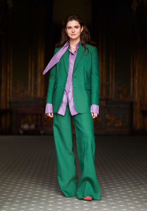 alison oliver poses in a green blazer and pants