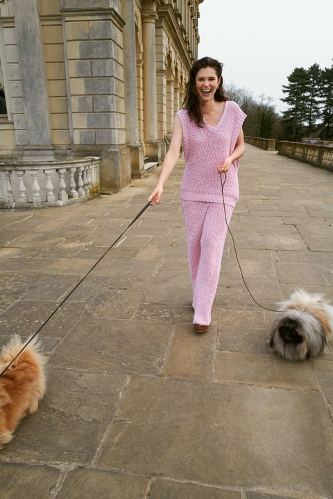 alison oliver laughs as she walks two dogs