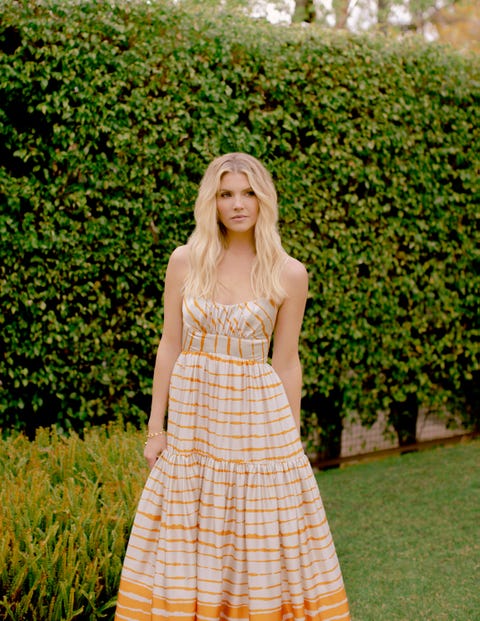 amanda kloots in an orange and white dress